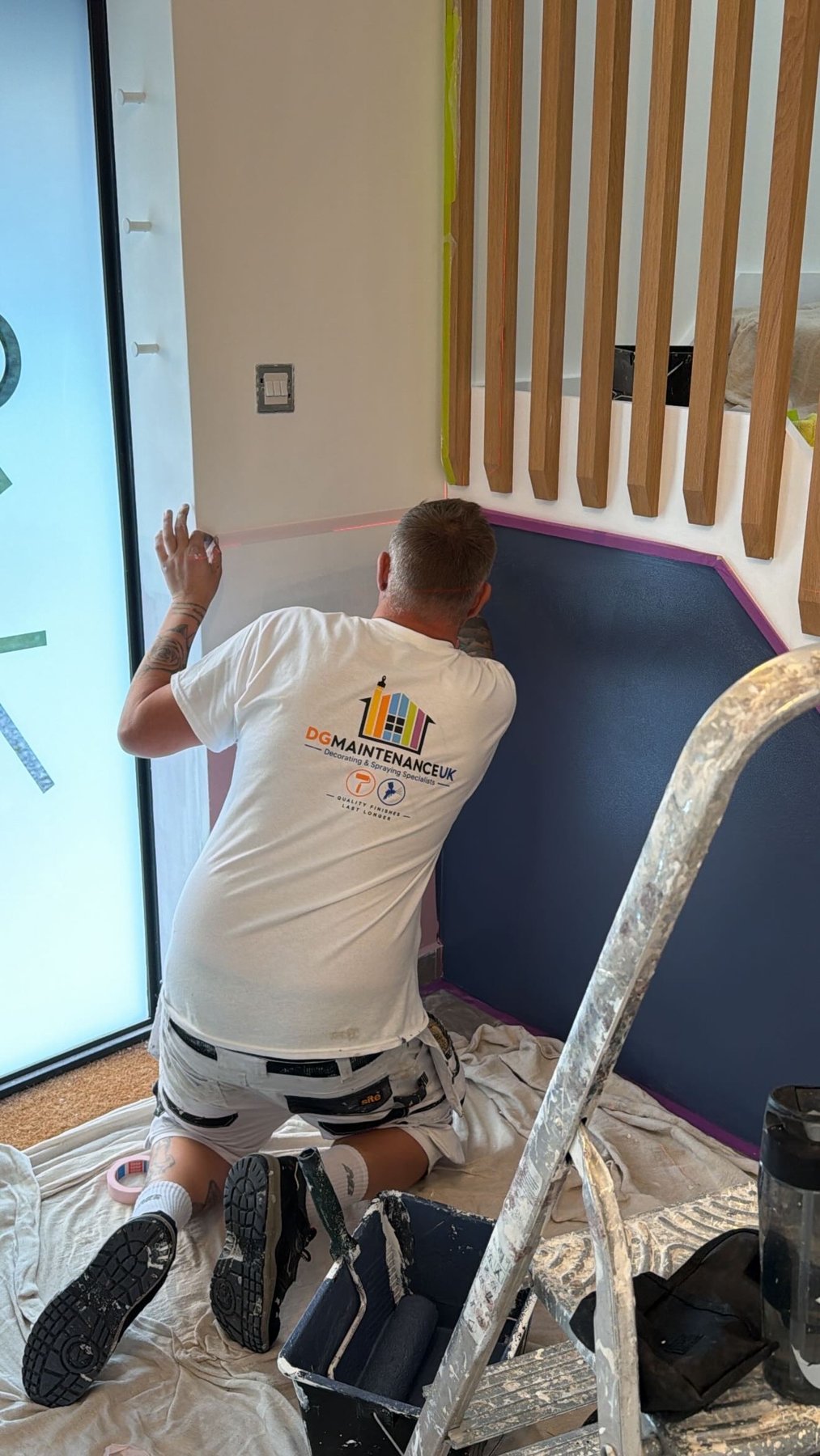 DG Maintenance UK decorator carefully masking the feature wall