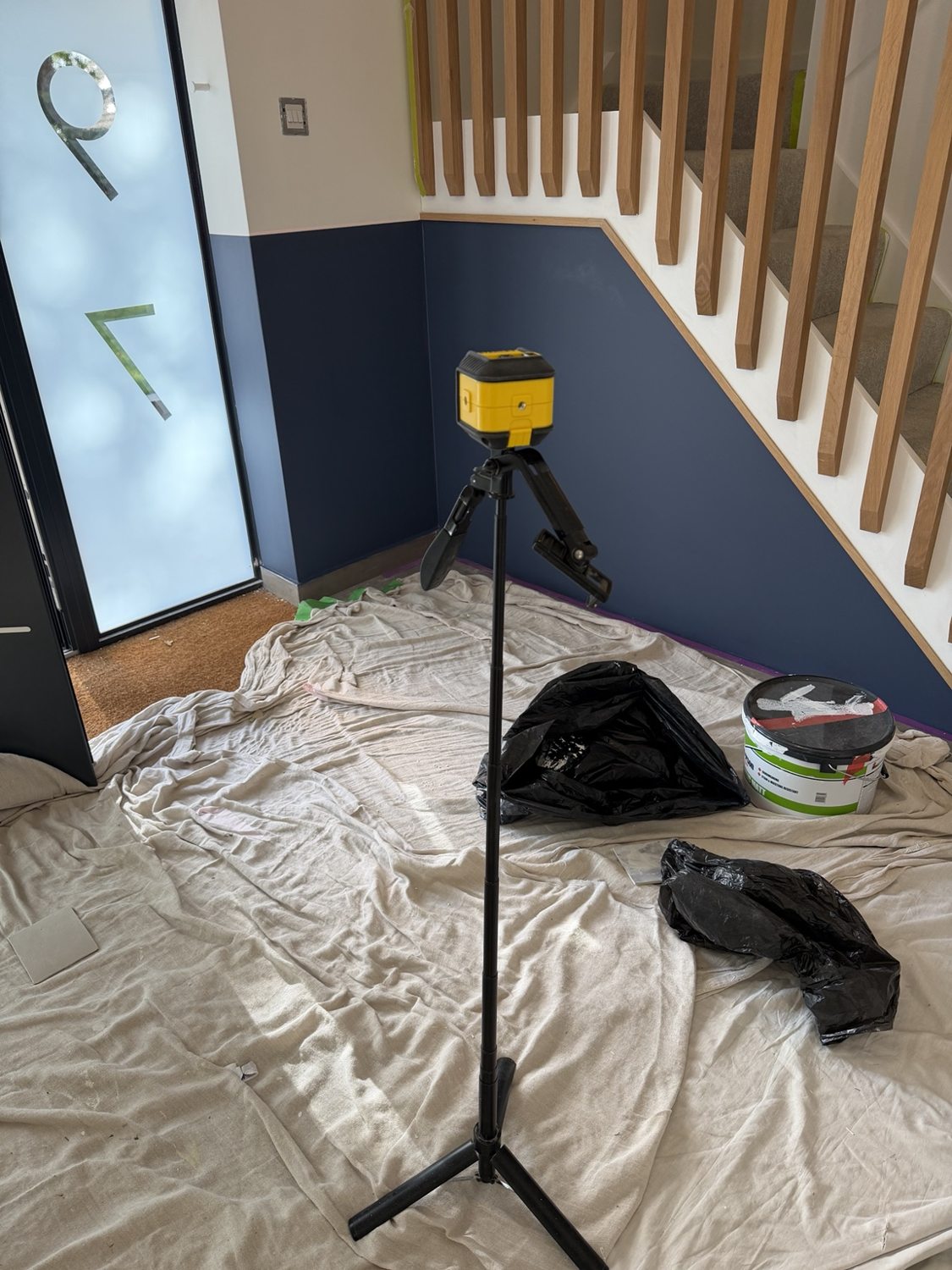 Laser level on tripod for accurate lines along the staircase feature wall