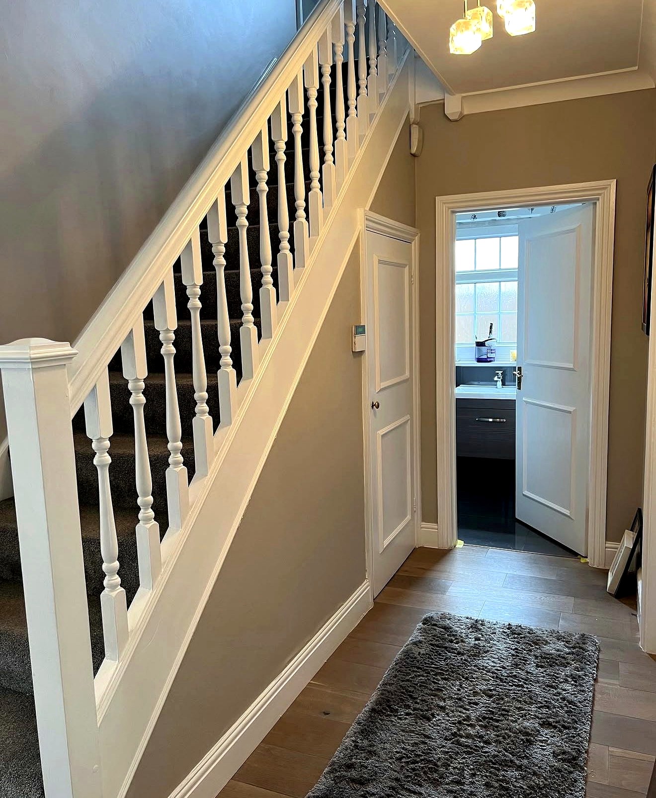 Finished grey hallway with white staircase