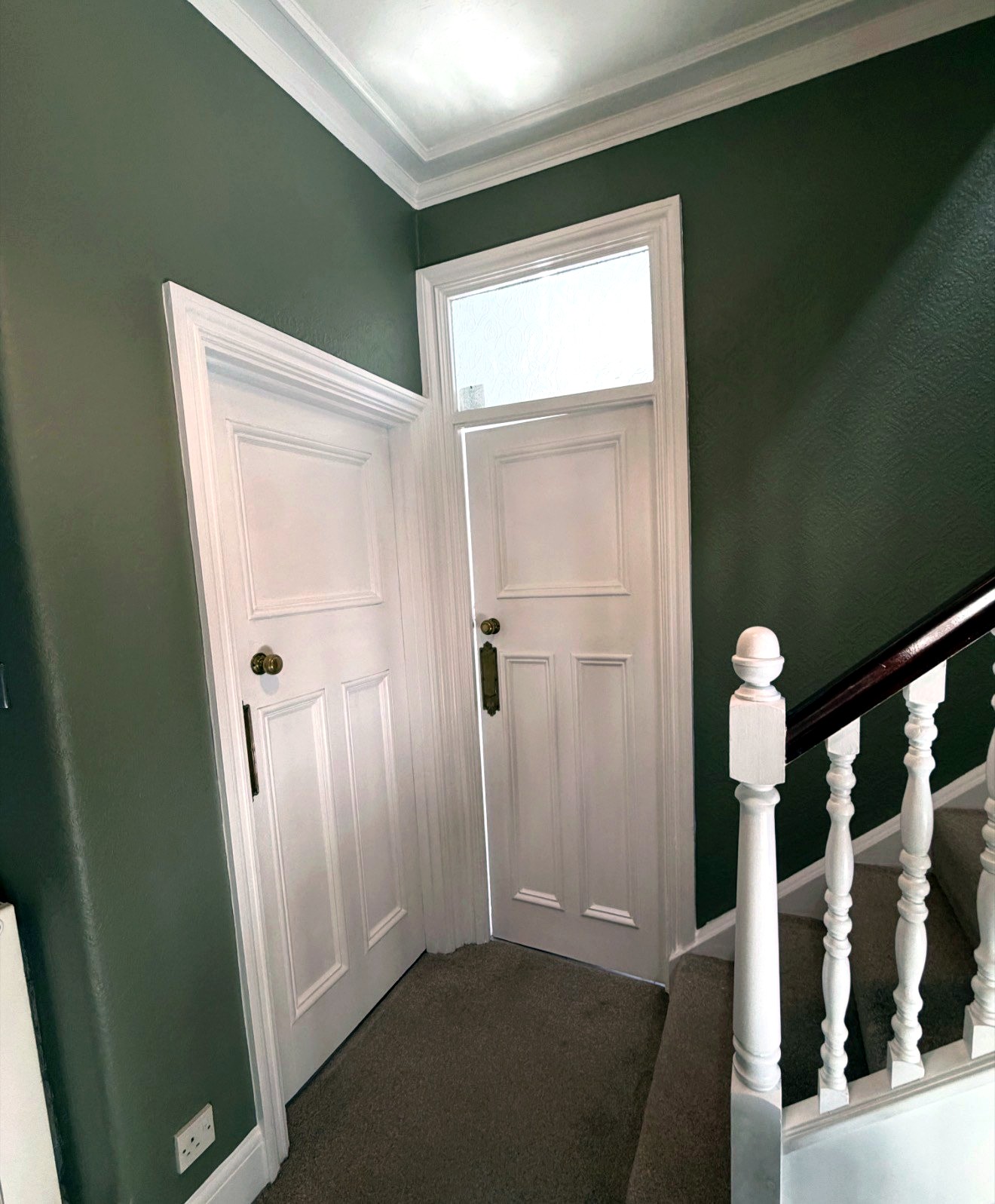 Period hallway with green walls and white woodwork