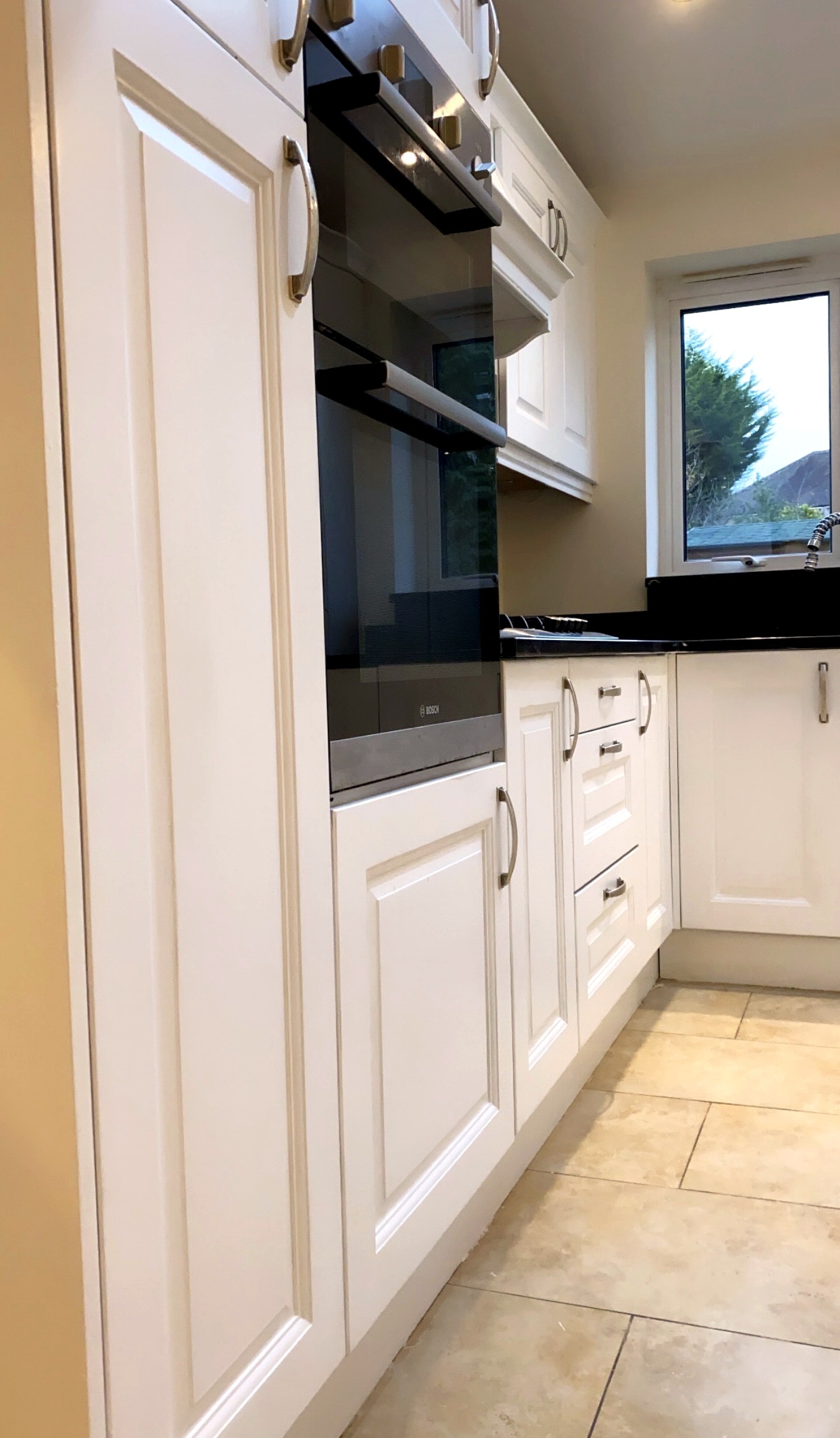 Finished sprayed white kitchen cabinetry and integrated appliances